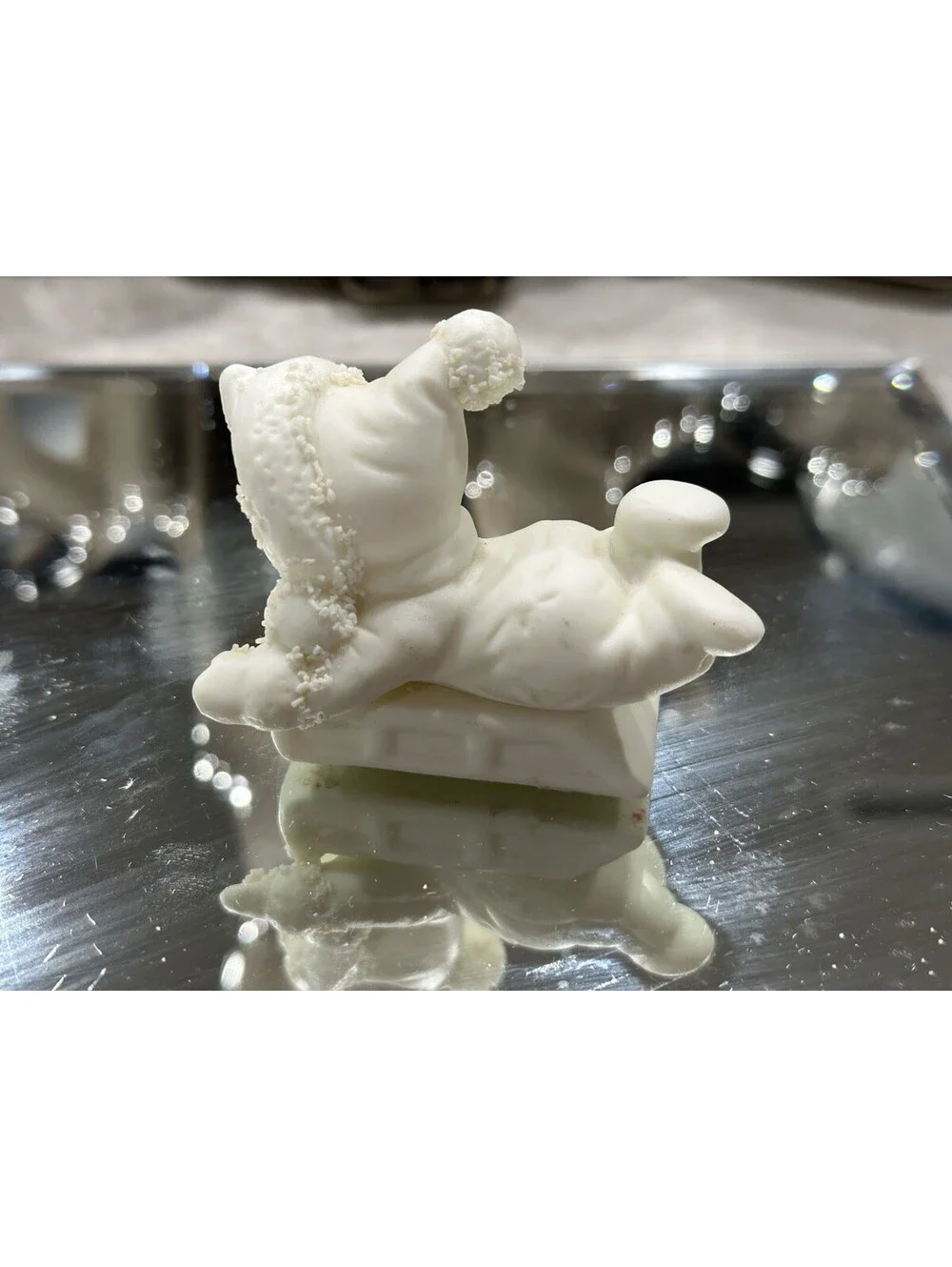 Department 56 Snowbabies figurine shows a baby dressed in a snowsuit playing